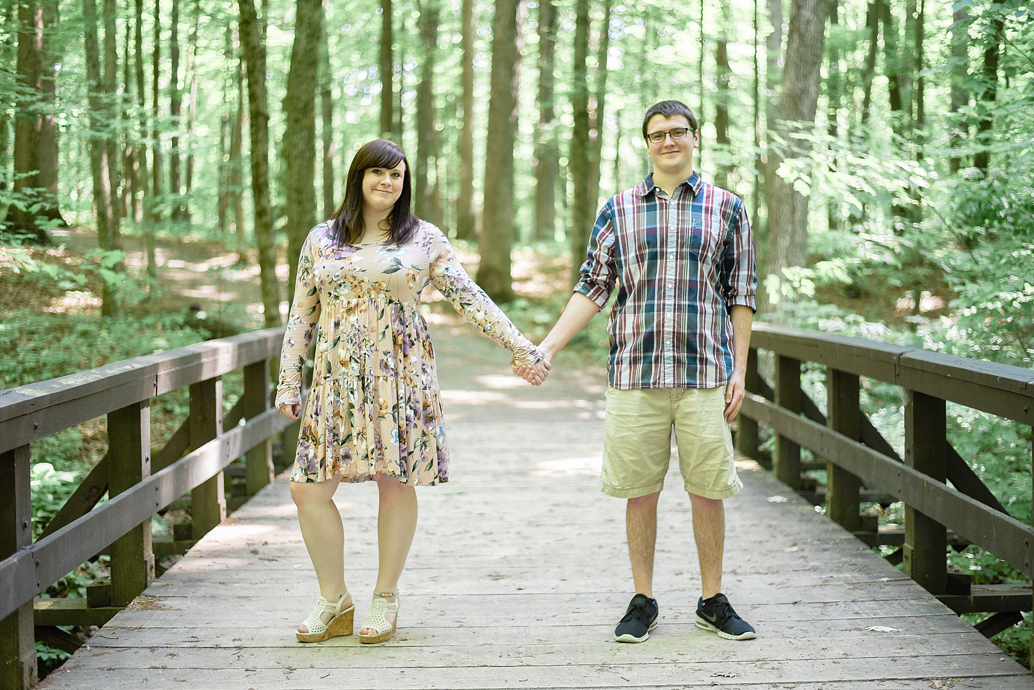 Couple holding hands on a bridge during their Highbanks Metro Park Engagement Session