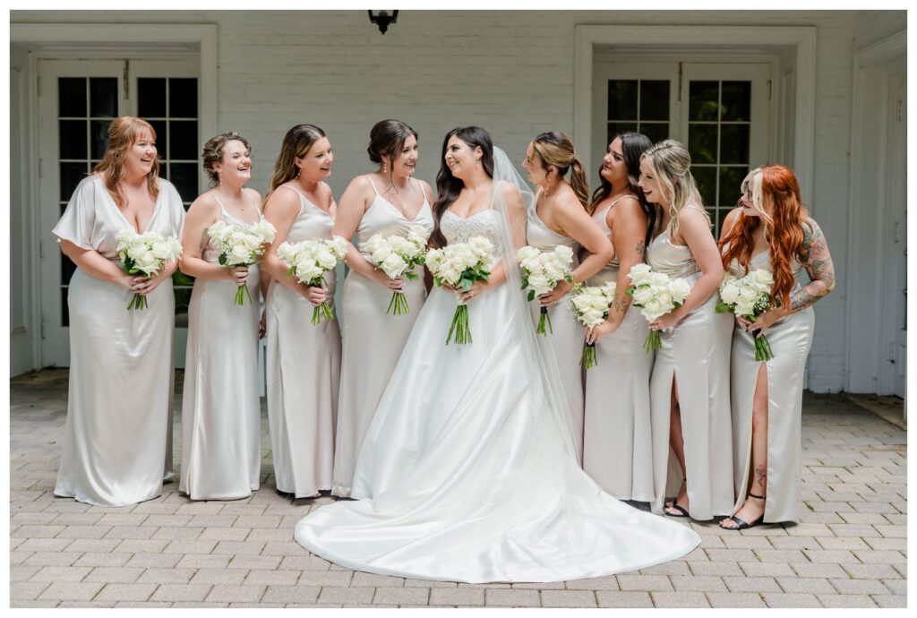 Hanah and her bridesmaids smiling at each other 